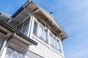 Old white wooden beach house with old windows in the sunshine