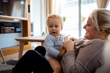 Mother playing with her toddler in the living room