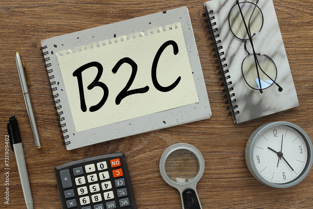 Poster b2c. commerce, marketing and strategy concepts. gray notepad with text on a torn page. a table clock