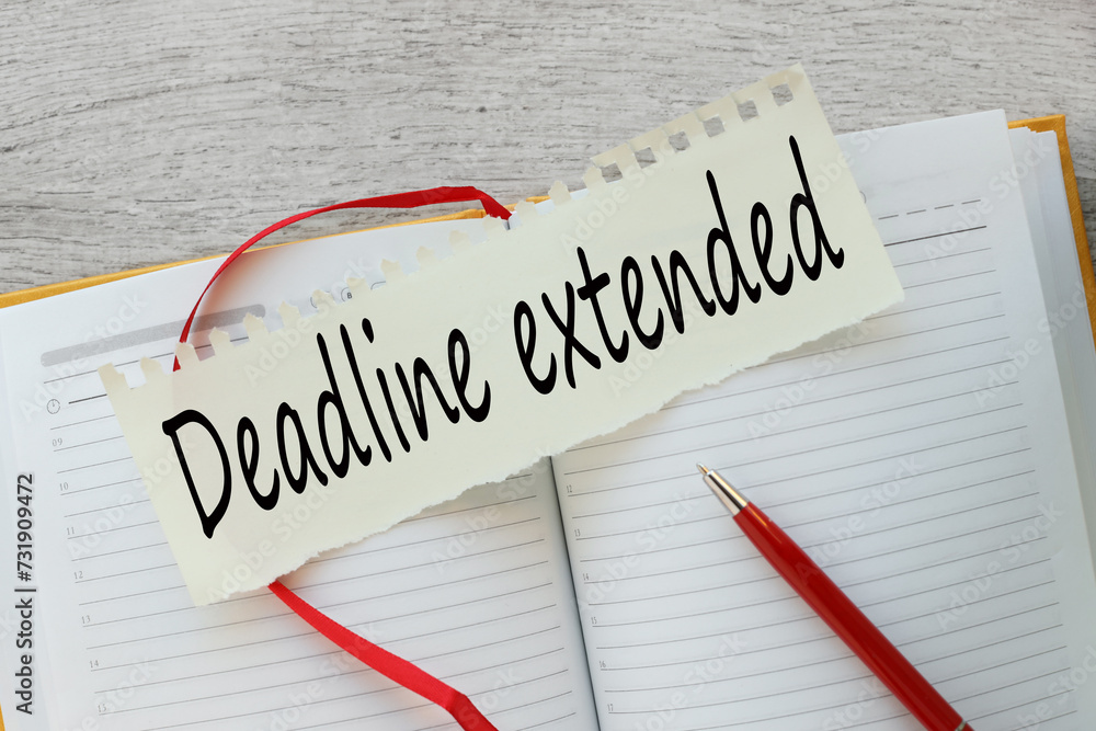 Poster deadline extended. text on torn paper. notepad on work desk