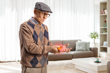 Elderly man in pain holding his red inflamed wrist