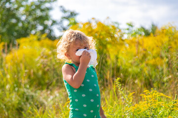 A child is allergic to ragweed blooming in the park. Selective focus.