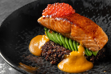 Fried salmon steak with caviar and avocado