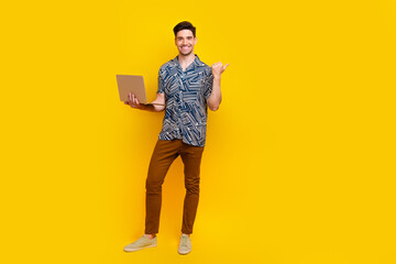 Full length photo of optimistic man dressed print shirt hold laptop indicating at offer empty space...