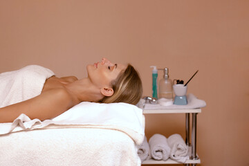 Obraz na płótnie Canvas blonde woman client lie in spa salon ready for massage and spa procedures