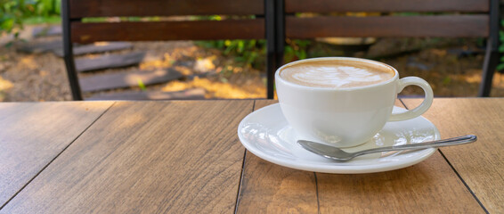 Top view of Latte coffee or cappuccino coffee in vintage cup with beautiful tree latte art on wooden table.