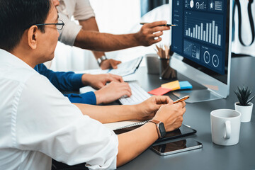 Data analysts team working analyzing business intelligence BI dashboard display on laptop to...