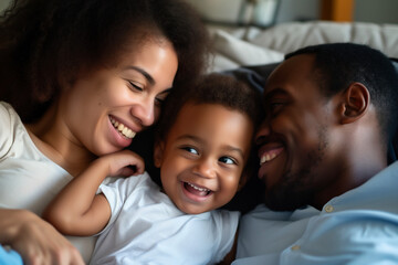 Obraz premium happy african american family laughing while lying on sofa at home