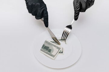 Business lunch concept. Female hands in black gloves hold fork with knife and cut off a piece from...