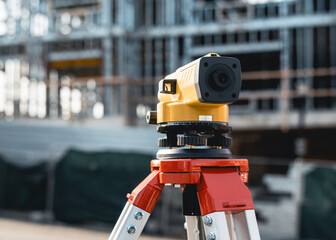 Builders automatic level on a tripod at the construction site