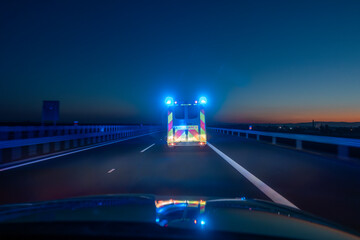 Fast moving ambulance car of emergency medical service on highway at night. Themes health care,...
