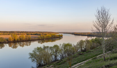 Wide river in autumn evening, view from the height of the hill.