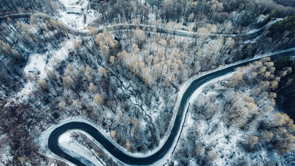 Aerial view of winding mountain road in winter.