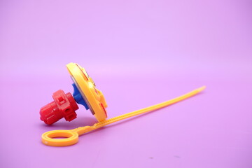 spinning top toy isolated on purple background