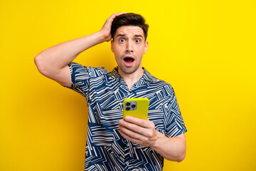Photo of speechless man with bristle dressed blue clothes hold smartphone arm on head read comment...