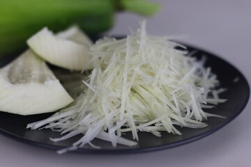 Fresh raw green papaya and shredded papaya on display, perfect for healthy recipes and vibrant salads
