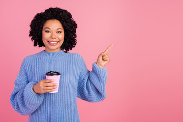 Photo of pretty adorable lady dressed knitted sweater drinking tea to go pointing finger empty...