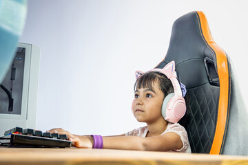 Girl in front of a gamer computer. She wears pink headphones with cat ears. She stares at the...