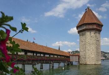 Fototapeta na wymiar Photo of castle bridge and tower over the Reuss River in Lucerne Switzerland accented with white swans