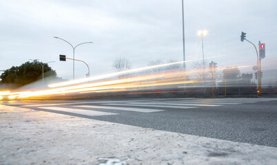 Fototapeta na wymiar Trail of car headlights speeding by on the road.