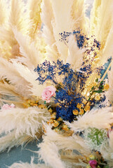 Colorful flowers surrounded by a cortaderia in a wedding arch