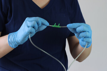 Professional wearing gloves holding a nasal cannula for oxygen delivery. Professional simulating...