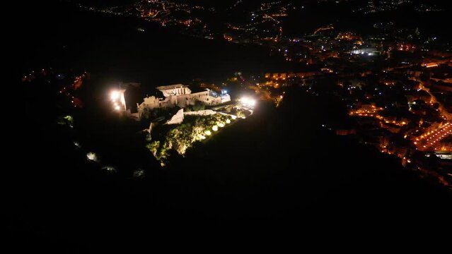 drone: vista su Castello Arechi di Salerno. Campania, Italia. Movimento a svelare panorama: citt&agrave;, piazza della libert&agrave;, porto. Notte.
