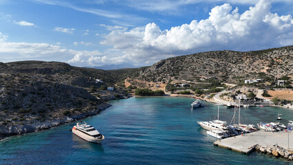 Obraz premium Aerial drone photo of small port of Schoinousa island a safe harbour to yachts and sail boats featuring small beach of Myrsini covered in Almirikia trees, Small Cyclades, Greece