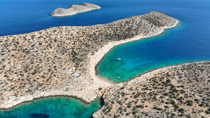 Aerial drone photo from tropical exotic paradise secluded rocky island bay with deep turquoise and sapphire sea forming a blue lagoon visited by yachts and sail boats in Caribbean exotic destination