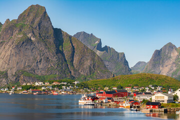 The most famous fishing village Reine with traditional red fisherman's cabins on Lofoten islands,...