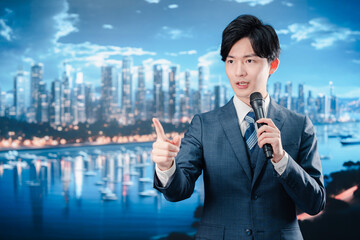 野外でマイクを使って話すスーツを着た男性