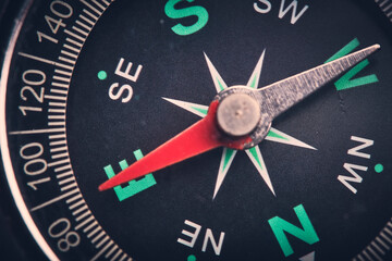 Dial compass in closeup, arrow indicates direction east.