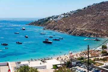 Fototapeta na wymiar Psarou beach in Mykonos, Greece, umbrella and luxury beach services. Psarou beach is the favorite of international stars, truly a paradise with spectacular landscape and all its comforts