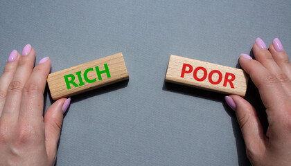 Rich vs Poor symbol. Concept word Rich vs Poor on wooden blocks. Businessman hand. Beautiful grey background. Business and Rich vs Poor concept. Copy space