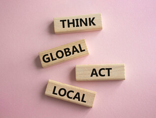 Think global act local symbol. Wooden blocks with words Think global act local. Beautiful pink background. Business and Think global act local concept. Copy space.