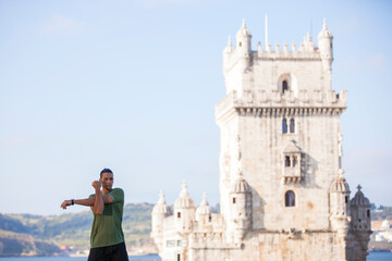 Young man doing exercise near Belém Tower