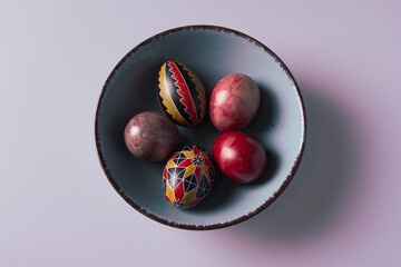 Easter eggs in a bowl on a light background with copy space