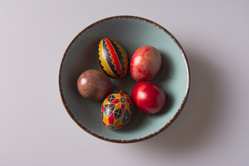 Easter eggs in a bowl on a light background with copy space