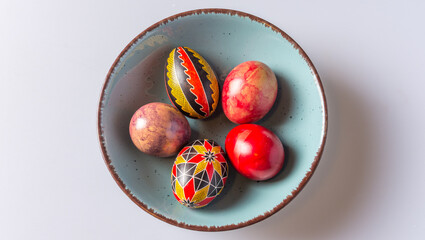 Easter eggs in a bowl on a light background with copy space