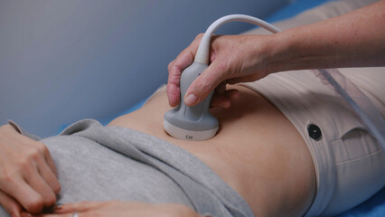 Medical specialist performs stomach ultrasound examination to patient using advanced medical...