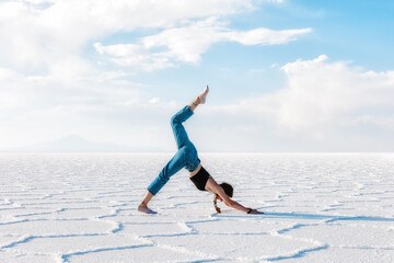 A girl does yoga outdoors. Salar de Uyuni salt plateau. Bolivia