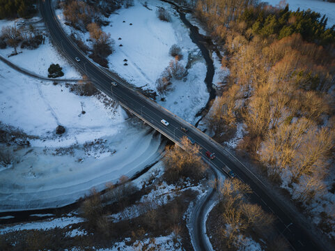 Cars drive across the Iru bridge over the Pirita River, drone photo on a winter morning.