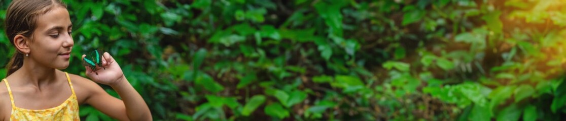A child holds a beautiful butterfly. Selective focus.