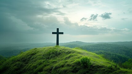A Christian cross standing tall atop a lush green hill. large copyspace area - 732034692