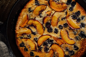 top down view of blackberry peach Flaugnarde (similar to Clafoutis) in cast iron pan