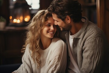 Young couple in love in knitted sweaters hug each other tenderly and going to kiss in a room