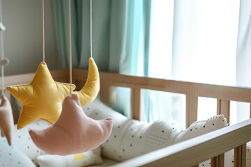 Fototapeta na wymiar Scandinavian Baby crib mobile with textile stars and flowers
