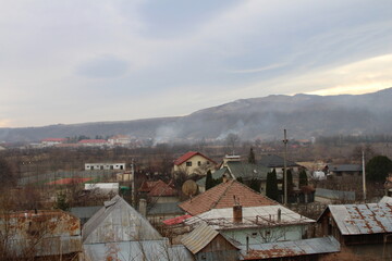 A city with many rooftops and mountains in the background