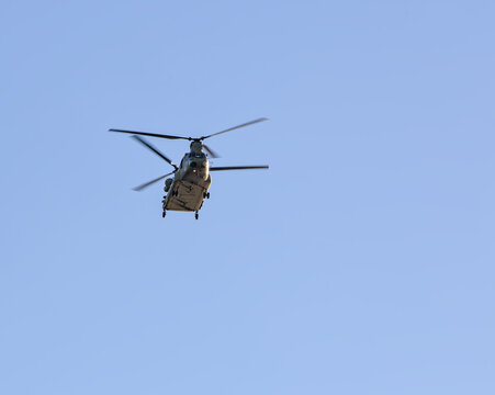 military helicopters flying in blue sky (chinook style chopper with double blades) two copters (presidential transport over hudson river in new york city)