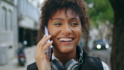Happy woman talking smartphone on city walk close up. African girl call outdoors - obrazy, fototapety, plakaty